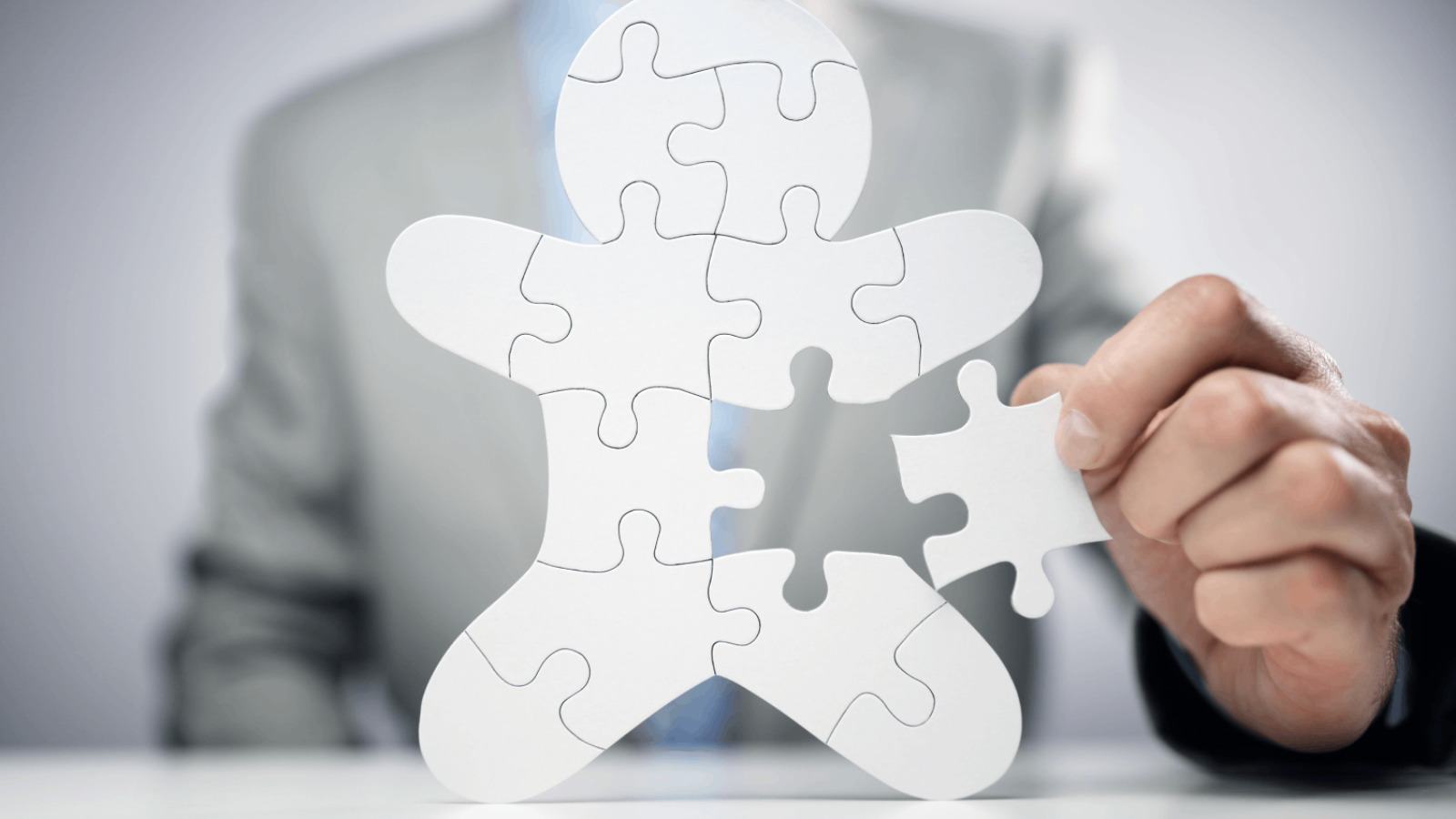 businessman-assembling-jigsaw-puzzle-human-team-em-2021-08-26-22-29-57-utc